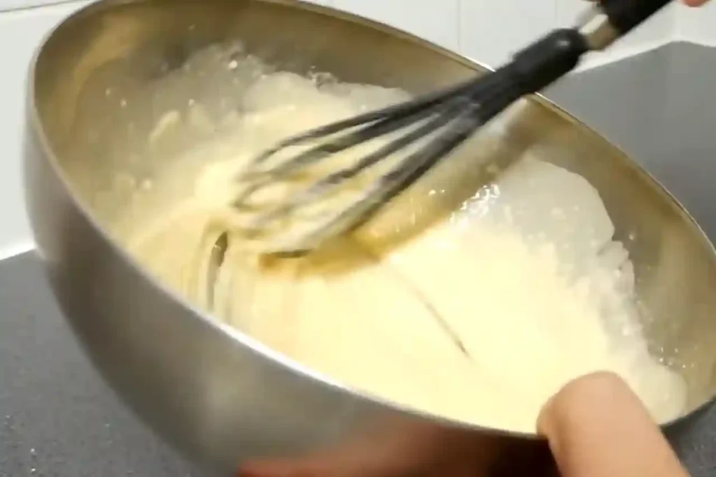 Whisking buttermilk marinade for crispy homemade chicken tenders