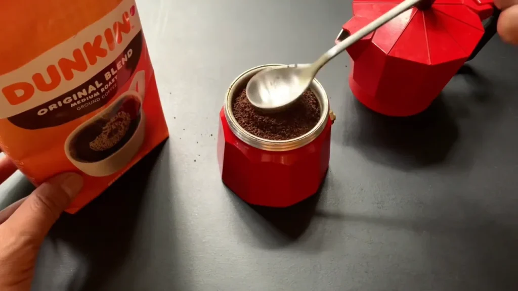 Adding coffee to a Dunkin cup for a homemade viral iced coffee recipe