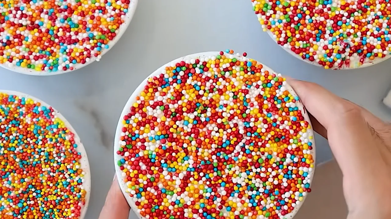 Finished dot cake covered with colorful frosting dots and rainbow sprinkles ready to serve