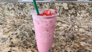 Easy Starbucks Pink Drink Recipe At Home garnished with fresh strawberry slices and served chilled in a clear cup