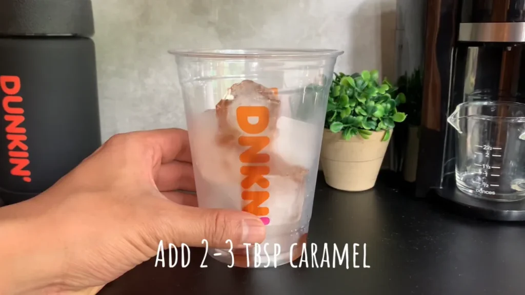 Preparing ice in a Dunkin cup for a viral iced coffee drink recipe