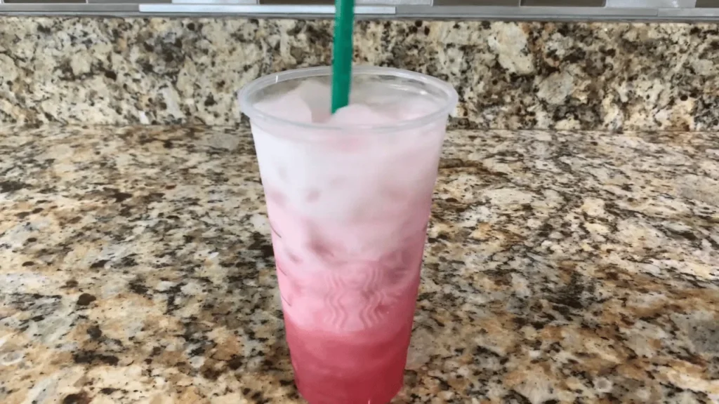 Homemade pink drink being shaken until creamy and frothy with coconut milk and strawberry refresher