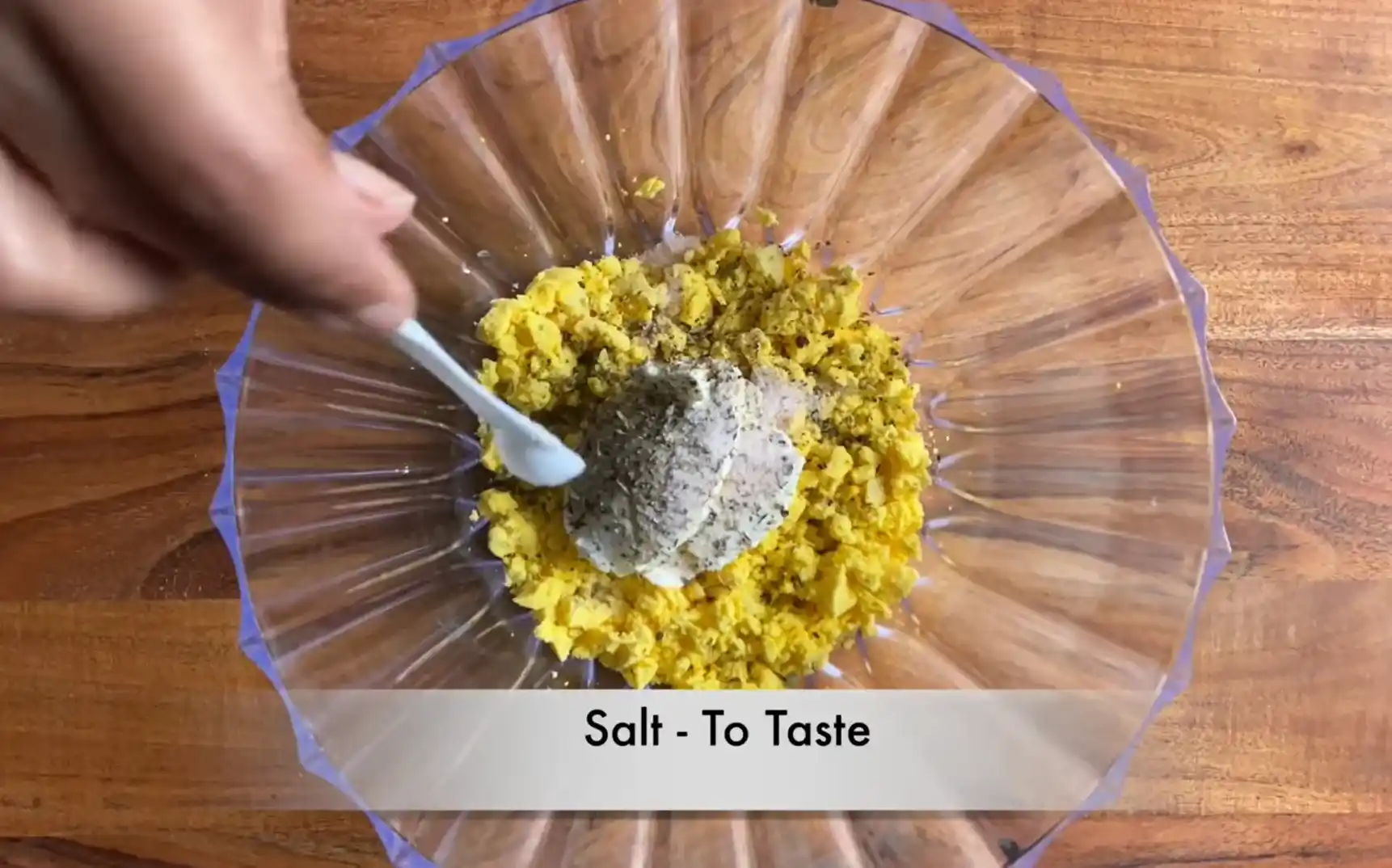 Adding salt to taste into egg yolk and hung yogurt mixture