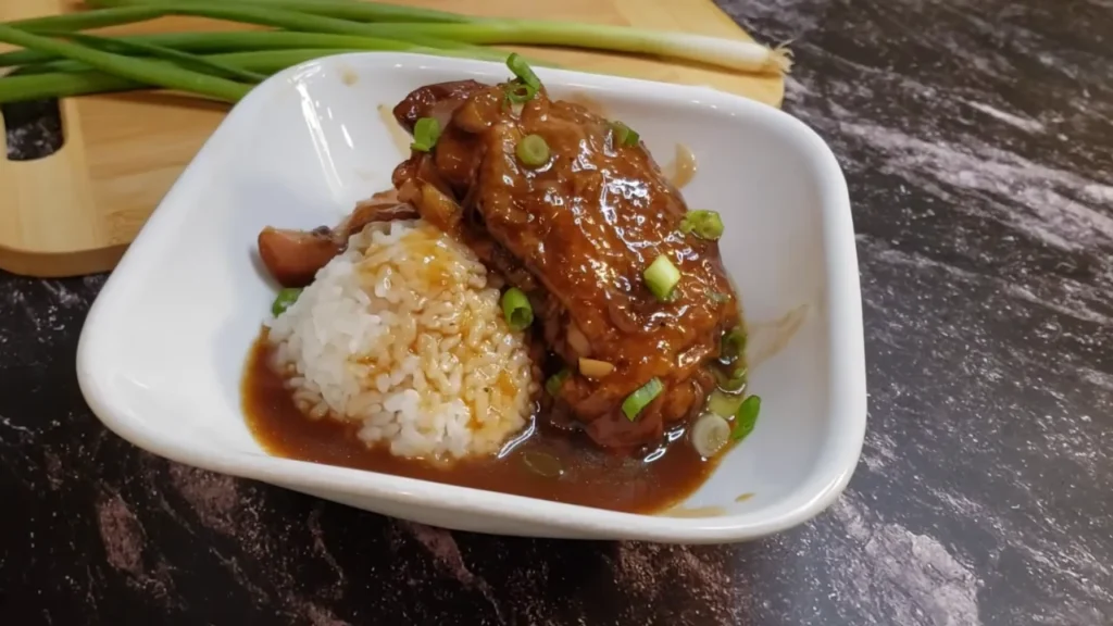 Hawaiian shoyu chicken served with white rice in a bowl, garnished with green onions