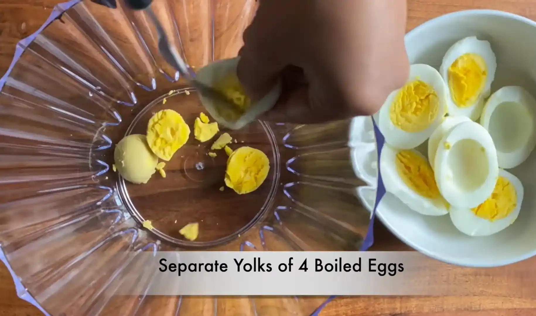 Separating 4 boiled egg yolks into a glass bowl for high protein egg salad sandwich