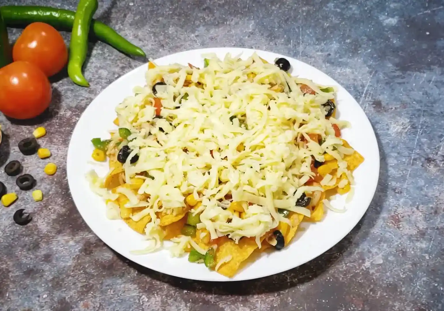Layering tortilla chips with seasoned vegetables and a blanket of shredded mozzarella cheese before baking