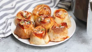 Plated crispy air fryer pizza rolls garnished with parmesan and fresh herbs