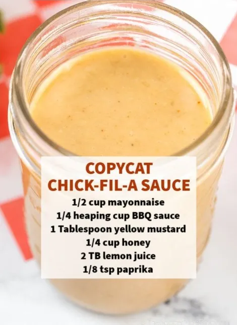 A glass jar filled with homemade Chick-fil-A sauce, with text overlays pointing out the key ingredients: mayonnaise, honey, yellow mustard, Dijon mustard, lemon juice, BBQ sauce, and apple cider vinegar