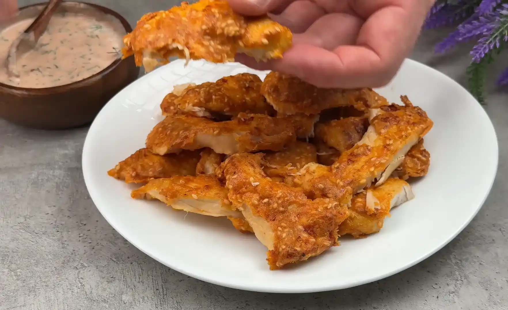Plated crispy air fryer sesame chicken strips served with creamy dipping sauce