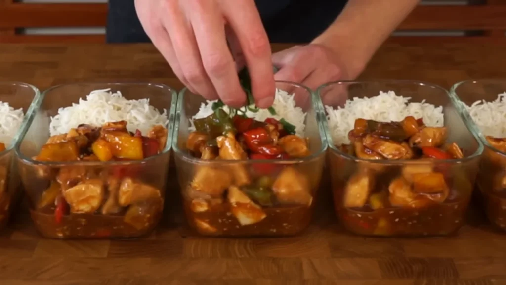 Portioning easy low carb chicken and rice meal prep bowls into glass containers to avoid hidden carbs from store bought sauces.