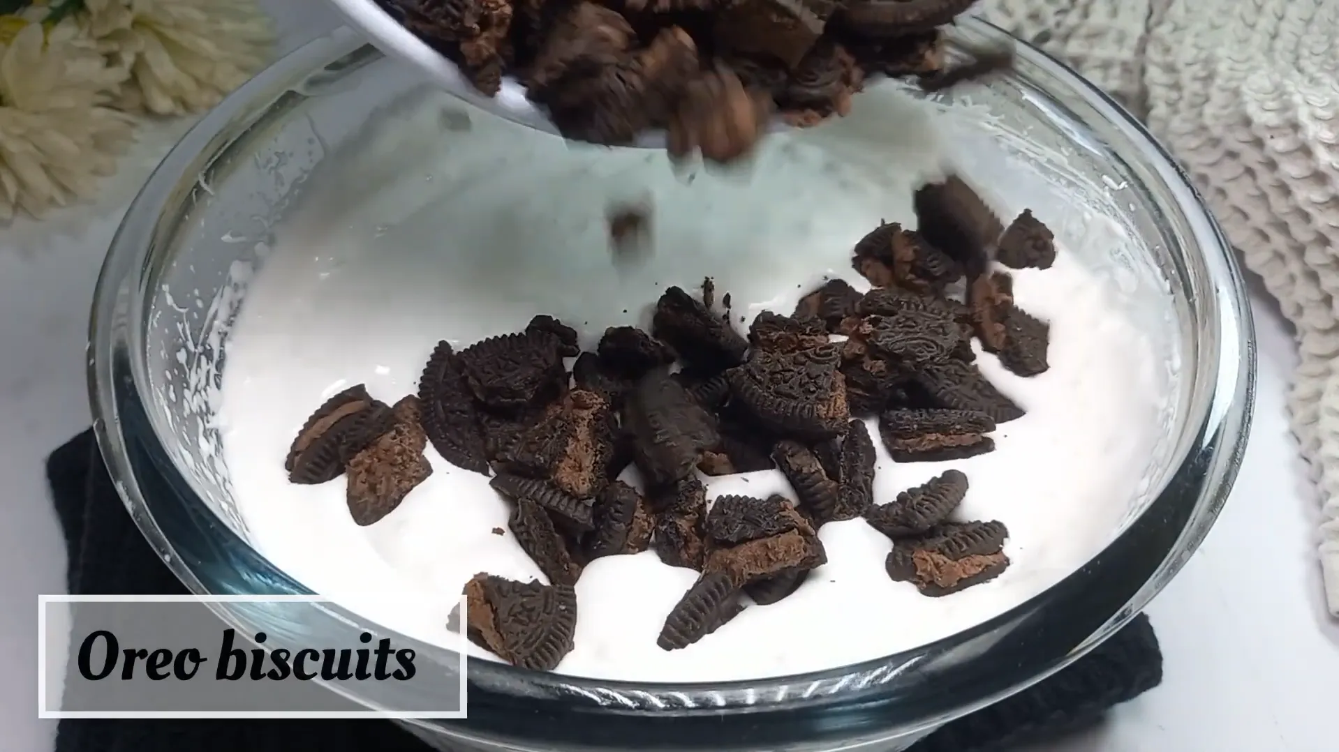 Folding crushed Oreo biscuits into whipped cream ice cream base