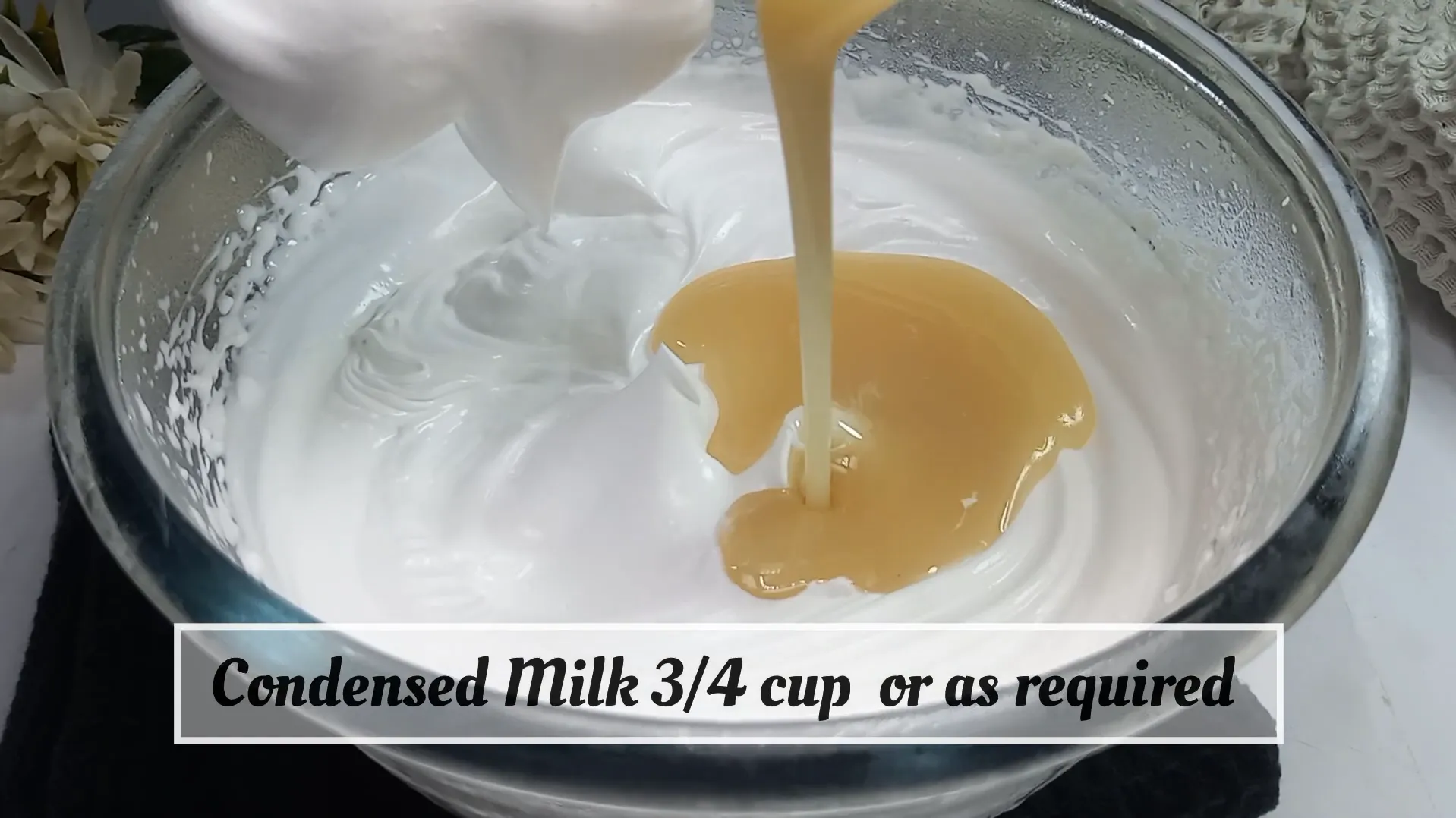Pouring 3/4 cup of sweetened condensed milk into fluffy whipped cream