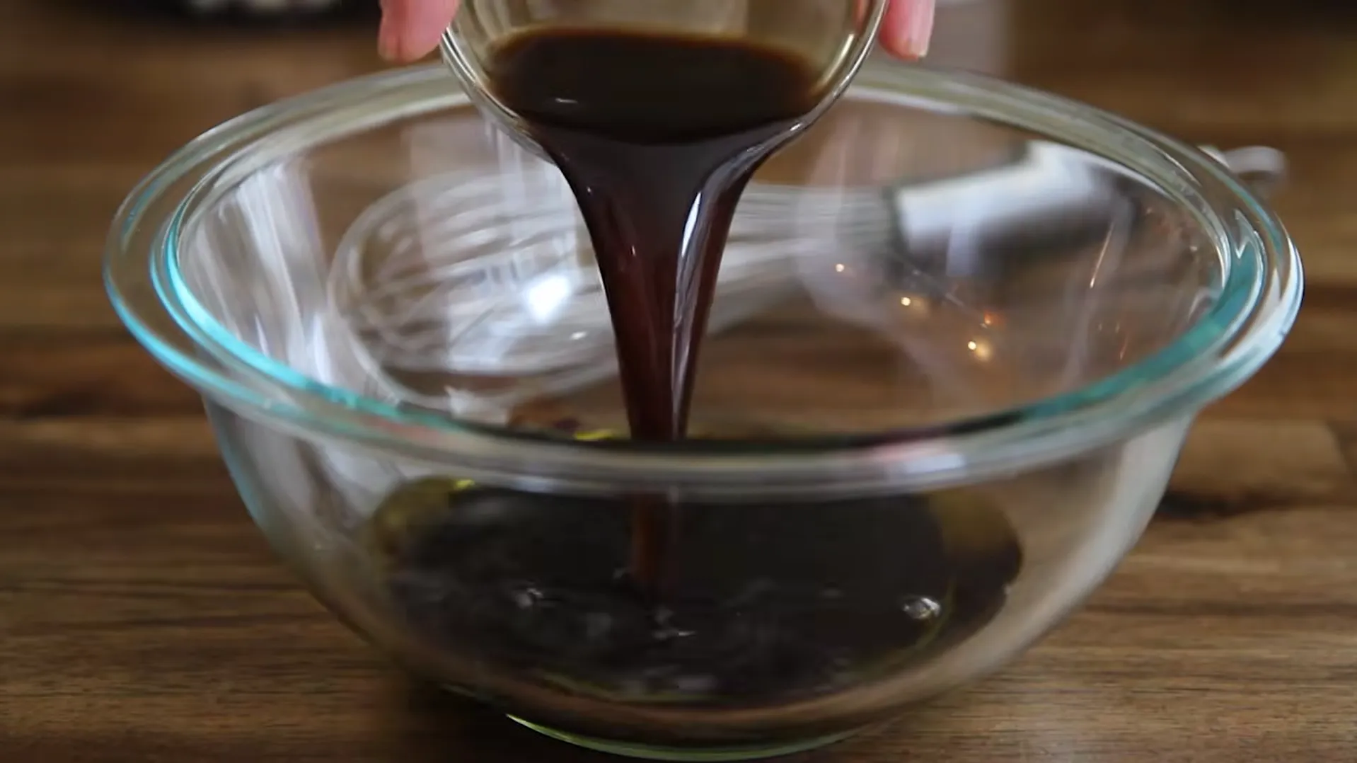 Soy sauce being poured into olive oil to make a flavorful homemade steak marinade