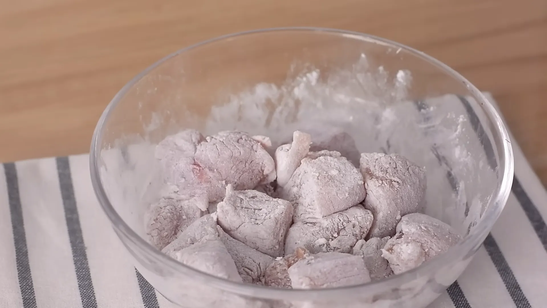 chicken pieces coated with cornstarch in glass bowl chicken pieces coated with cornstarch in glass bowl