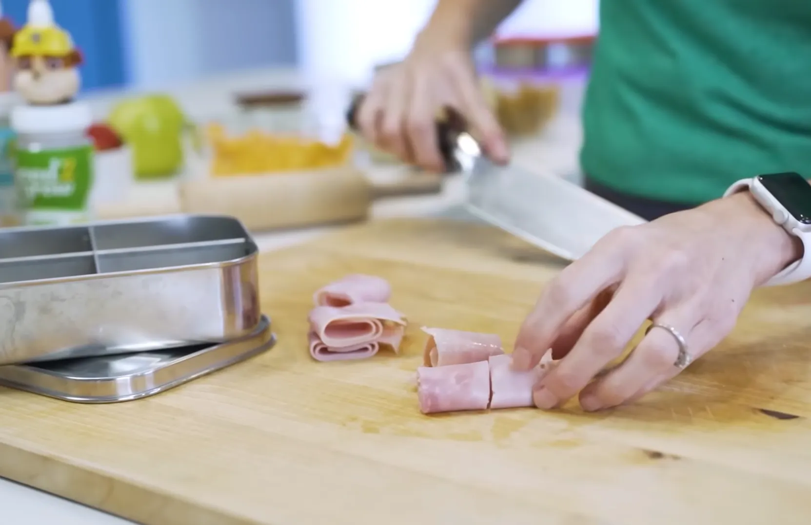 Slicing rolled deli ham into bite-sized pieces for kids bento box protein options