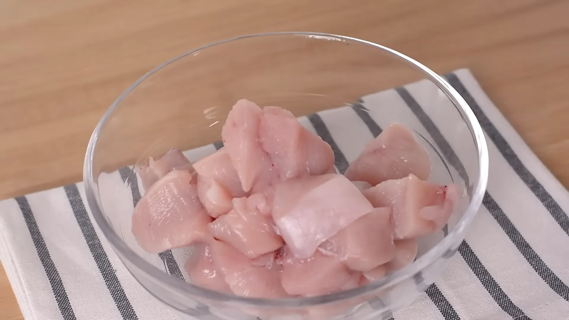 chicken cut into bite sized cubes in glass bowl chicken cut into bite sized cubes in glass bowl
