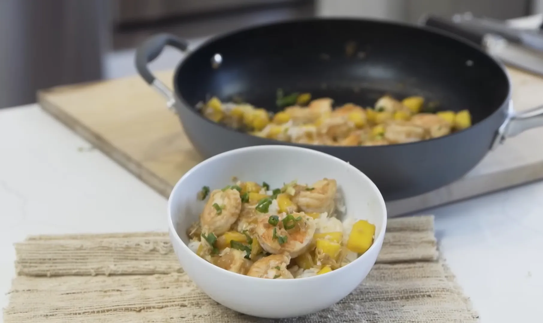 Serve the mango shrimp over warm rice for a light, 20-minute dinner Mango shrimp skillet served over rice in a white bowl