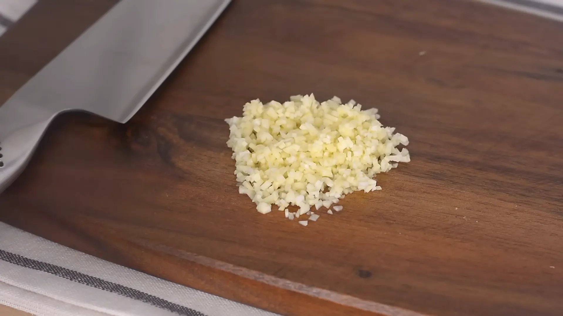 finely minced garlic on wooden cutting board finely minced garlic on wooden cutting board