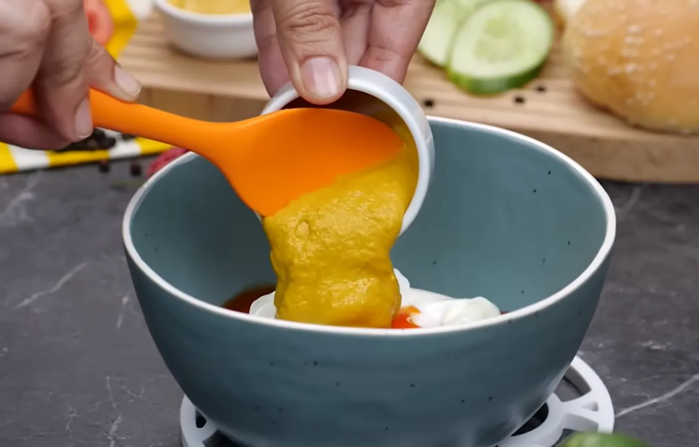 Adding yellow mustard to mayonnaise and hot sauce for burger sauce