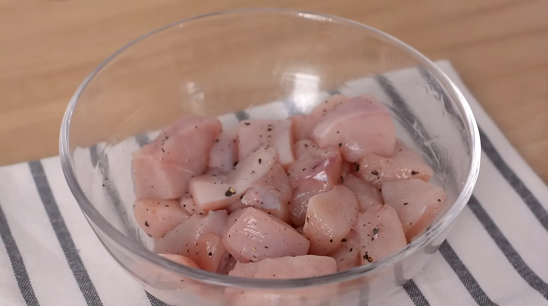 chicken cubes seasoned with salt and black pepper in bowl chicken cubes seasoned with salt and black pepper in bowl