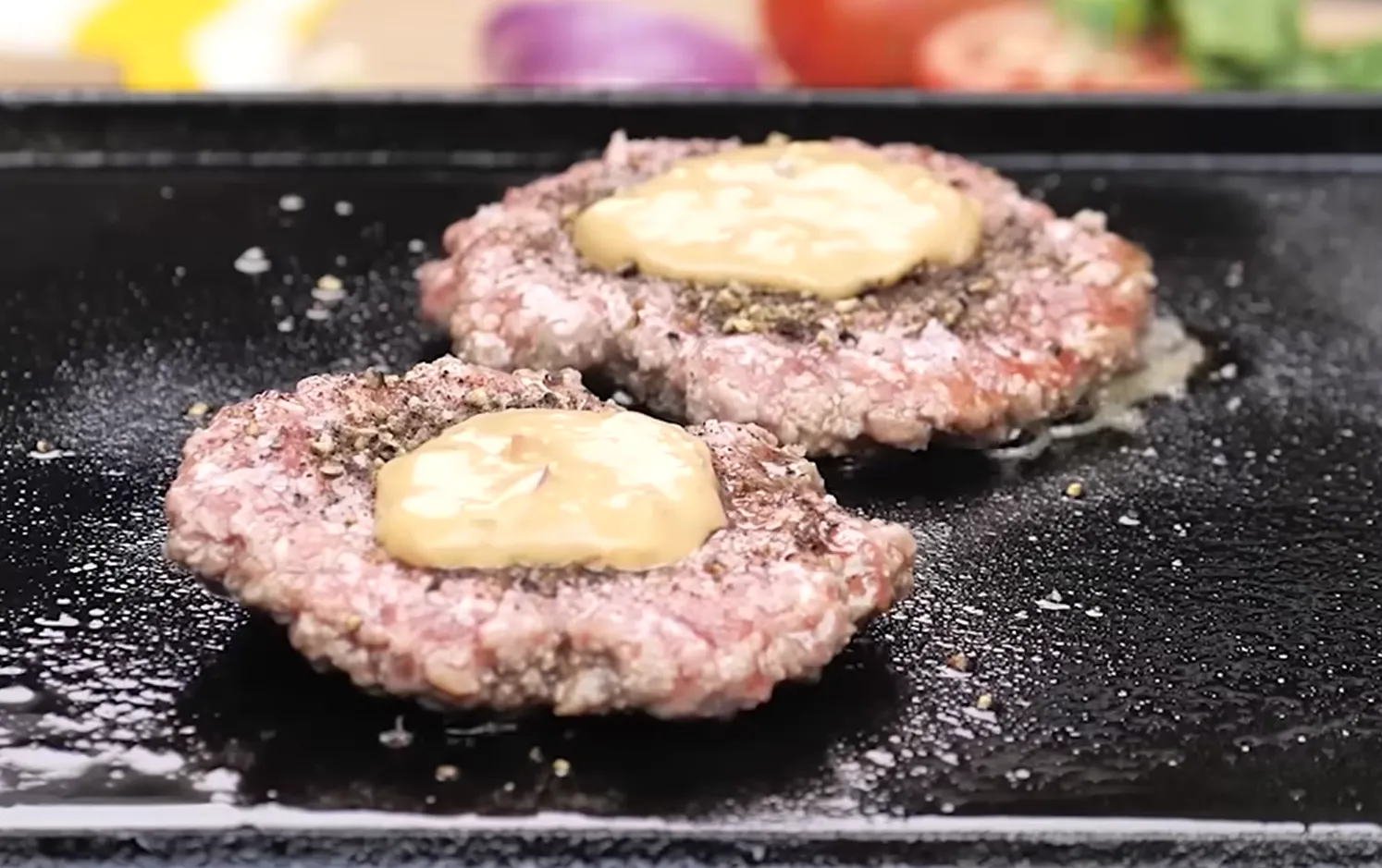 Searing smash burger patties with mustard