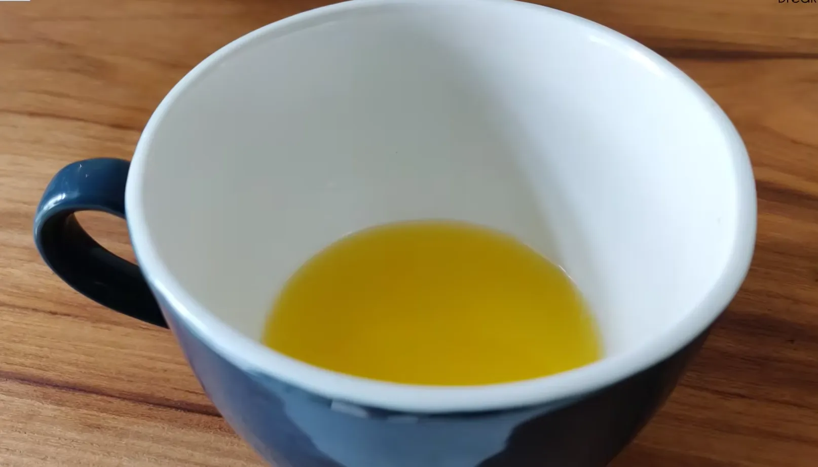 Pouring oil into a mug to start chocolate mug cake batter